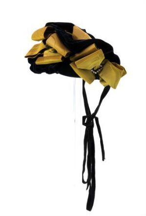  A picture of a theatrical yellow hat with black ribbons on a white background, intended to convey the contrasting colors and playful design of the object. Artist name and title are unknown.