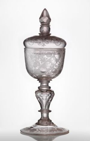  An intricately detailed and clear glass goblet with a lid, featuring engraved or frosted patterns, against a white background.