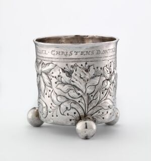  An intricately decorated silver beger by Rasmus Jochimsen Haveman, featuring a repoussé foliage motif, standing on three spherical feet with a slightly flared opening.