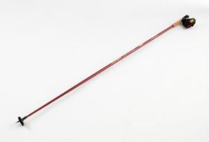  A single Swix Sport AS ski pole with a burgundy shaft and black grip and basket, lying on a light background.