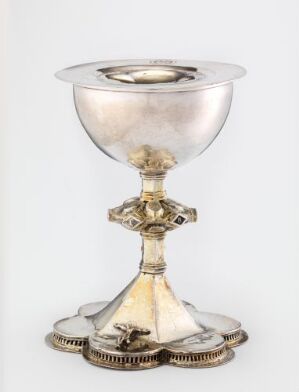  The "Alterkalk" chalice by an unidentified artist is a finely crafted ecclesiastical vessel made from gilded, hammered, cast, and engraved silver, featuring ornate decorative details, displayed against a neutral background.