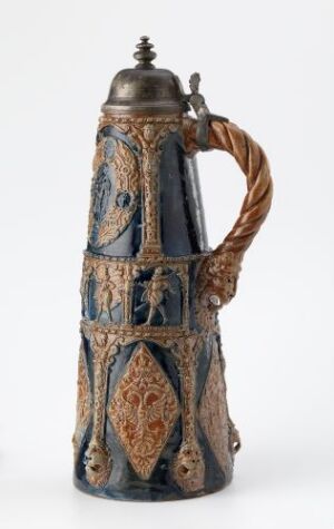  An intricately decorated ceramic beer stein with cobalt blue base and oval medallions of sandy beige, adorned with hand-painted scenes and vertical bands of silver-colored filigree, featuring a twisted handle and a hinged metal lid.