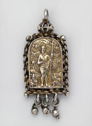  An ornate gold-colored pendant with a classical figure in relief, adorned with scrolling patterns and small hanging orbs, set against a plain background. Artist and title are unknown.