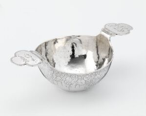  A "Øreskål" by Aegidius Loidt—a small engraved and chased silver bowl with decorative handles sitting on a light gray surface against a white background.