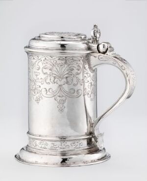  A silver drinking jug titled "Drikkekanne," by artist Lucas Andersen Steen, featuring intricate engravings and a polished handle with a reflective finish, against a light-gray background.