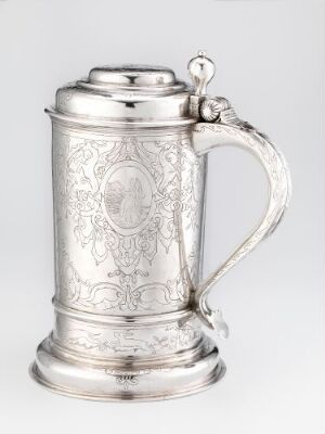  An engraved silver drinking pitcher titled "Drikkekanne" by artist Hinrich Meyer, featuring a cylindrical shape with ornate floral engravings, a hinged lid with a finial on top, and an ergonomic handle. The polished silver surface gleams with shades of gray reflecting the light.