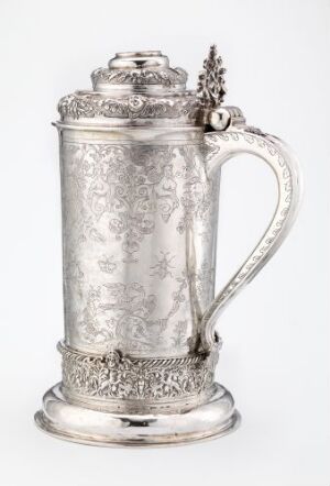  A silver drinking pitcher, "Drikkekanne," by Lucas Andersen Steen, with intricate engravings covering its body, a curved handle, and a decorative lid, showcasing historical craftsmanship in silverwork.