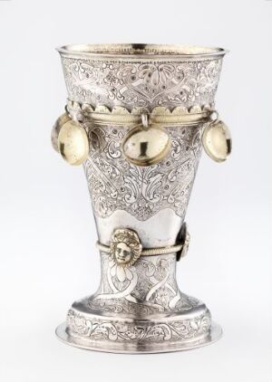  A decorative silver goblet titled "Beger" by an unidentified artist, featuring intricate patterns and gold gilding, with spherical gold ornaments dangling from a band on the upper section.