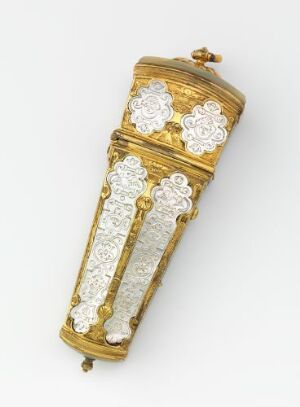  A luxurious, elongated gilded bronze "Nécessaire" with intricate engravings and panels of iridescent mother-of-pearl, reflecting a rich golden hue against a pearlescent white background, crafted by an unidentified artist. The object has a sophisticated, ornate appearance indicative of personal grooming elegance from a bygone era.