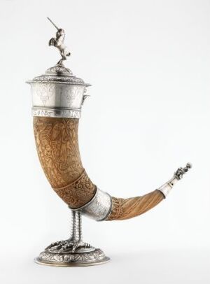  "Velkenhornet," a historical drinking horn made from carved ox horn with exquisitely crafted silver mounts, lid, and foot, featuring detailed chiseled and engraved decoration, created by an unidentified artist.