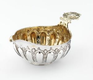  An intricately crafted silver "Øreskål" by an unidentified artist, featuring a patterned exterior with arch or crown-like motifs and a gilded interior that shines with a warm, golden luster.