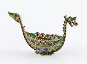  A decorative metallic vessel with an enamelled green body and colorful circular medallions on the sides, stylized with a curling head and tail featuring gemstone embellishments, on a white background. Artistname and title unknown.