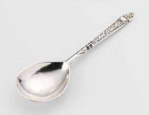  A silver spoon titled "Spiseskje" by Jochum Jochumsen Kirsebom, showcasing a polished bowl and an ornately engraved handle with floral designs, against a light gray background.