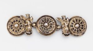  A set of four linked, ornately patterned golden circular metallic pieces, possibly part of a bracelet or decorative clothing accessory, against a light grey background.