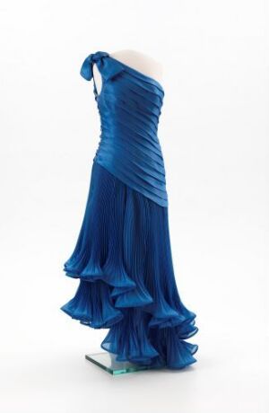  A mannequin wearing a rich royal blue evening gown with ruching and ruffles, designed as a strapless floor-length dress, displayed against a plain white background.