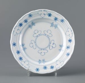  A white feldspar porcelain plate titled "Facon Meissen" by Gerhard Munthe featuring hand-painted underglaze decoration of stylized blue flowers and geometric patterns around the edge, embodying refined elegance and craftsmanship.