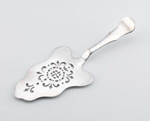  A decorative silver cake server with an intricate openwork floral pattern against a neutral light gray background.