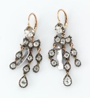  A pair of vintage-style drop earrings with clear crystals set in darkened metal, featuring a combination of round, oval, and marquise cuts arranged in a symmetrical floral-inspired design.