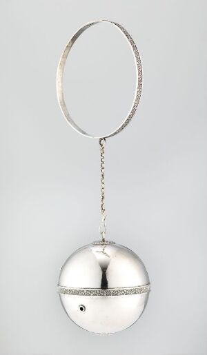  A polished, silver spherical ornament with a hinged closure, suspended by a chain with a loop on top, against a light grey background. The artist's name and title of the piece are unknown.