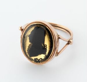  "Niels Boegh til Ødemark" - A gold ring crafted by an unidentified artist featuring a hammered and soldered gold band that divides into a double band holding an oval bezel with a painted black silhouette profile portrait against a gold backdrop, bordered by small white pearls.