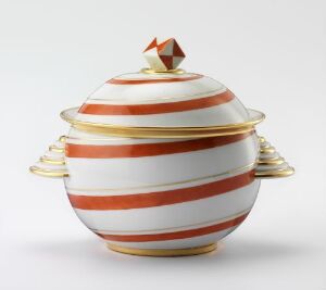  A feldspar porcelain soup tureen with horizontal stripes in orange and white, designed by Nora Gulbrandsen. It features a spherical body with a lid topped by an orange and gold faceted finial, and golden accented handles.