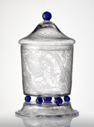  A translucent glass jar with frosted etchings and cobalt blue accents, featuring three glass feet and a finial knob on the lid, set against a neutral background.