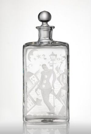  "Drukken Harleqin," a clear, blown and engraved glass container designed by John Bothner featuring a dynamic Harlequin figure amidst festive motifs, demonstrating intricate craftsmanship and a whimsical design.