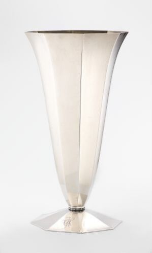  A modern, silver or chrome vase with an Art Deco design, reflecting light on a neutral white background. The vase tapers from a wide mouth to a narrow base, capturing elegance and simplicity.