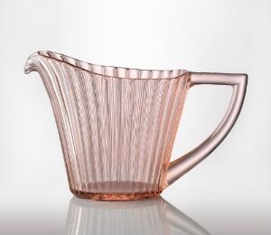  "Nordlys" by Høvik glassverk, featuring a translucent pink glass pitcher with vertical ridges, a broad spout, and a sturdy handle, exemplifying the technique of farget støpt glass pressing, set against a soft gray background.