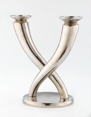  "Flèche" by Christofle, a silver-plated brass candelabra with intertwined branches forming a graceful X-shaped sculpture, rising from a circular base to hold two candles.