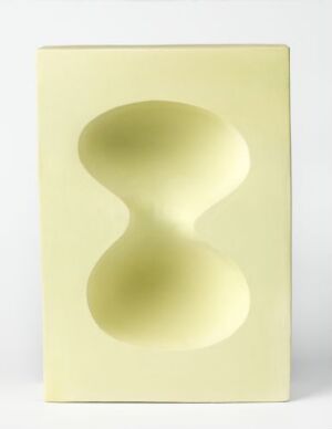  "Optica" by Elisabeth von Krogh, a pastel yellow ceramic decorative object with a three-dimensional hourglass-shaped indentation in the center, showcasing a play of light and shadow on its smooth surface.