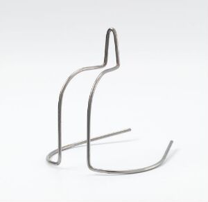  A minimalist metallic sculpture of a continuous metal rod shaped into curves and angles, resembling an abstracted figure against a light grey background.