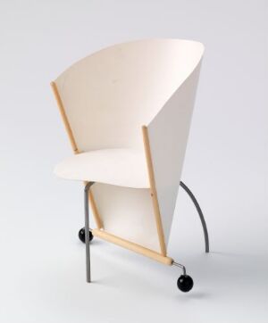  A modern chair with a continuous light beige seat and backrest, curved pale wooden legs, and two black castor wheels at the front, set against a pale gray background.