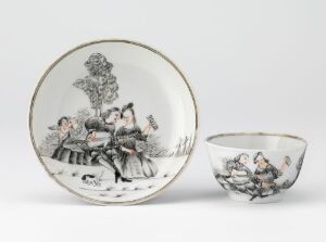  An antique porcelain plate and teacup set with black and white illustrations depicting 18th-century social scenes. The porcelain is off-white with detailed monochrome drawings of figures in period attire.