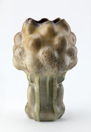  A muted green, stylized object resembling a closed plant or flower bud with a bulbous patterned top and a columnar stem, set against a white background.