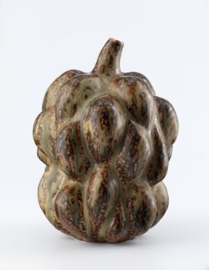  A sculptural ceramic object by Axel Salto, suggestive of a gourd or fruit with a mottled beige, brown, and green glaze, displaying intricate, natural-form bulges on a neutral grey background.