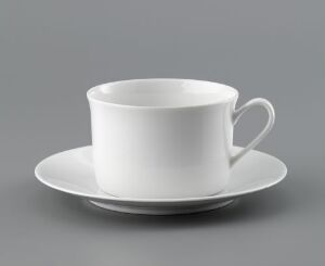  A classic white feldspar porcelain tea or coffee cup with a matching saucer created by Porsgrunds Porselænsfabrik AS, exhibiting a minimalist design with a gleaming, glazed finish on a neutral background.