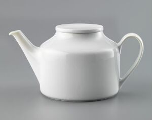  A white feldspar porcelain teapot with a glossy finish, designed by Tias Eckhoff, sits centered against a neutral gray background. The teapot features a minimalist and modern design, with a smooth, bulbous body, an ergonomic handle, a graceful spout, and a round lid with a small knob.