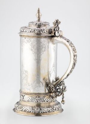  A silver drinking pitcher titled "Drikkekanne" by Jonas Andersen, showcasing elaborate embossed designs on the base and lid, with a smooth central section and a decorative handle featuring botanical motifs.