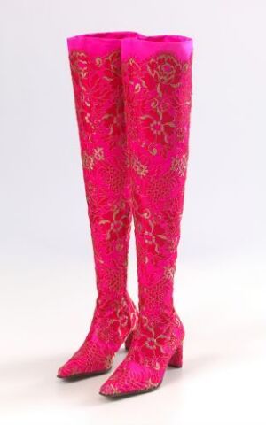  A pair of thigh-high boots in hot pink with hand-embroidered glass bead details and appliquéd golden flowers, titled "Orientalsk blomsterhave" by artist Vibeke Barbo, showcasing an Oriental floral theme with intricate golden thread weaving on a luxurious silk base.