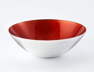  A simple, two-toned bowl with a sleek white exterior and a glossy red interior set against a light grey background.