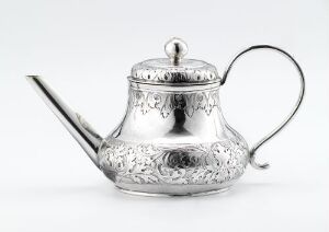  "Tekanne" by Andreas Borg, an intricately patterned silver teapot with a bulbous body, a curved handle, and a thin spout against a light grey-white background.