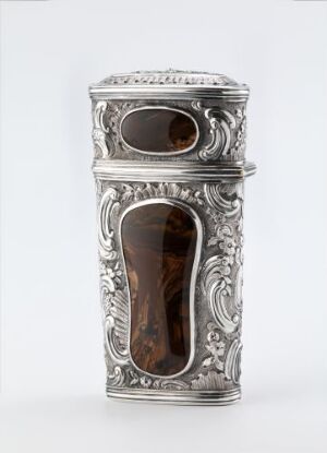  An ornate silver "Nécessaire" case, with intricate engravings and two Oval panels of polished agate, crafted by an unidentified artist. The case is set against a neutral background and reflects light beautifully, illustrating its detailed design and silverwork.