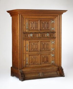  Traditional wooden cabinet with a mid-brown oak finish, featuring raised panel doors and metallic hardware, set against a plain background.