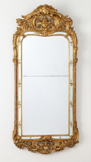  Elaborately carved and gilded pine wood frame surrounding a tall rectangular mirror, titled "Speil" by an unidentified artist, featuring intricate scroll and leaf motifs with a neutral backdrop.