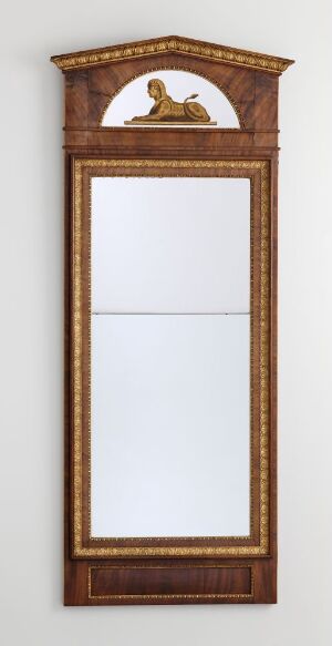  An antique-style tall rectangular mirror with a golden-brown wooden frame that features an ornate curved pediment on the top and a clear reflective surface, set against a plain white background.