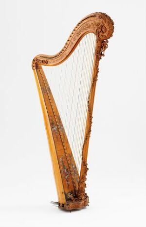  An ornately carved wooden harp with a natural varnished finish and white strings, set against a light, solid background.