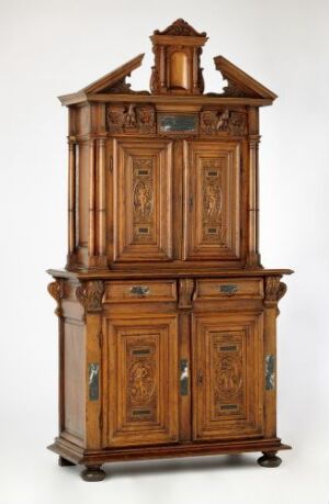  A detailed wooden walnut cabinet, titled "Skap" by an unidentified artist, with upper and lower sections featuring orn