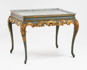  An ornate antique pine table titled "Tebord" by Heinrich Lorentzen Bech, featuring relief carving and painting with gold scrollwork and floral details on its curved legs, birch highlights, and a marbleized tabletop.