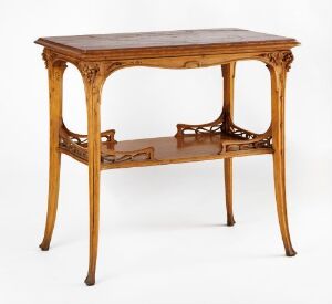  An antique wooden table with a decorative lower tier and intricately carved legs set against a white background.